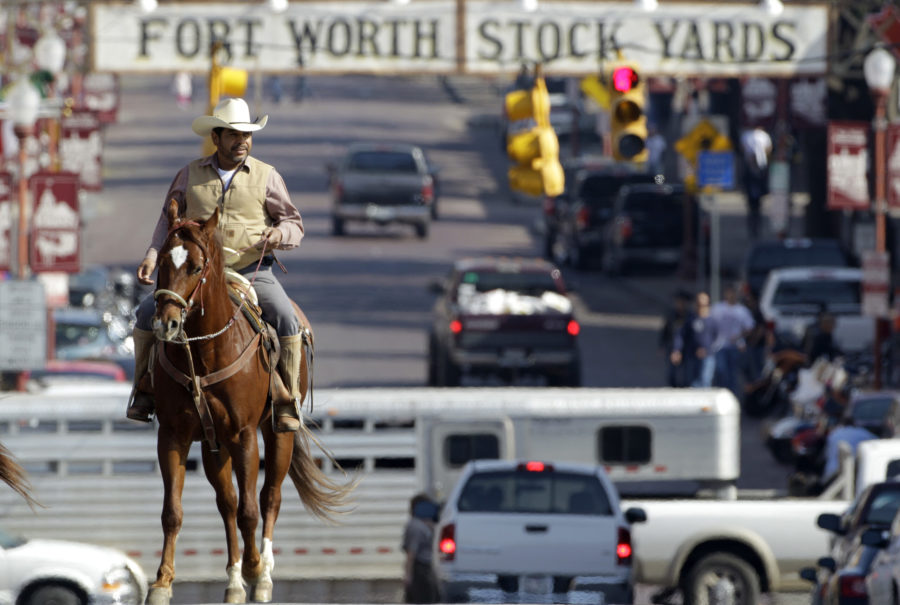 FILE - In this Jan. 30, 2011, file photo, Antonio Hinojosa, natively of Zacatecas, Mexico, currently living in Fort Worth, Texas, rides his horse up Exchange Ave. , in the historic Fort Worth Stockyards, in Fort Worth, Texas. Fort Worth Stockyards was identified by the National Trust for Historic Preservation as one of Americas 11 most endangered historic places. (AP Photo/Tony Gutierrez, File)