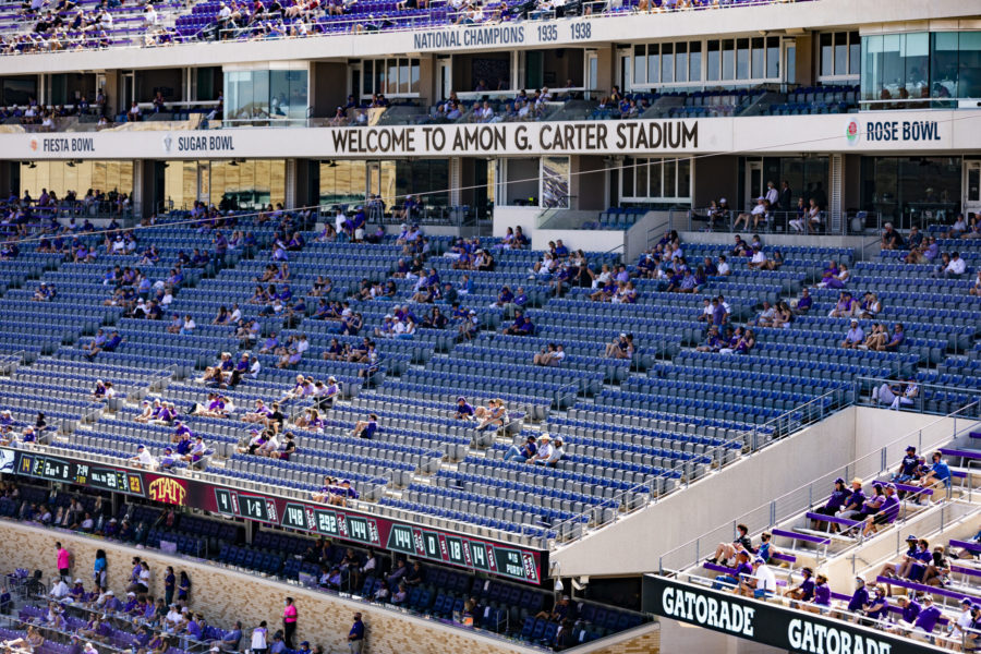 TCU fans sit socially distant in the stands during a football game.