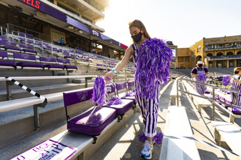 Liliana Ogden, a TCU Dutchmen, gets ready for the game by laying down pom-poms on every seat in the student section.