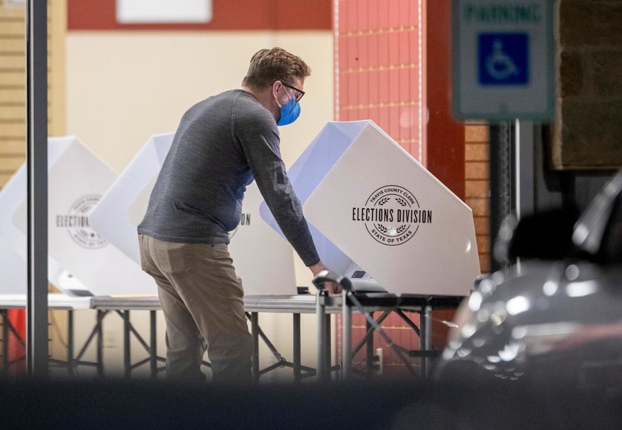 A man casts a ballot in the general election at an early voting location at the Shops at Arbor Walk, Tuesday, Oct. 13, 2020, in Austin, Texas. (Jay Janner/Austin American-Statesman via AP)