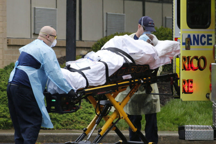 Members of the Henrico County Fire Department Emergency Services transport a patient of the Canterbury Rehabilitation & Healthcare Center Monday April 20, 2020, in Richmond, Va. The facility has reported dozens of COVID-19 deaths. (AP Photo/Steve Helber)