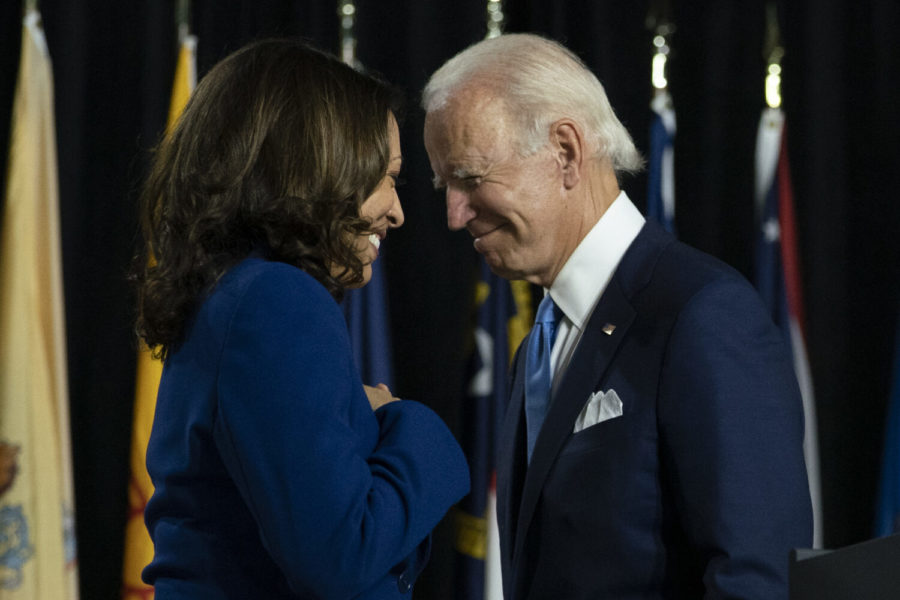 In this Aug. 12, 2020, file photo, Democratic presidential candidate former Vice President Joe Biden and his running mate Sen. Kamala Harris, D-Calif., pass each other as Harris moves to the podium to speak during a campaign event at Alexis Dupont High School in Wilmington, Del. Harris made history Saturday, Nov. 7,  as the first Black woman elected as vice president of the United States, shattering barriers that have kept men — almost all of them white — entrenched at the highest levels of American politics for more than two centuries. (AP Photo/Carolyn Kaster, File)