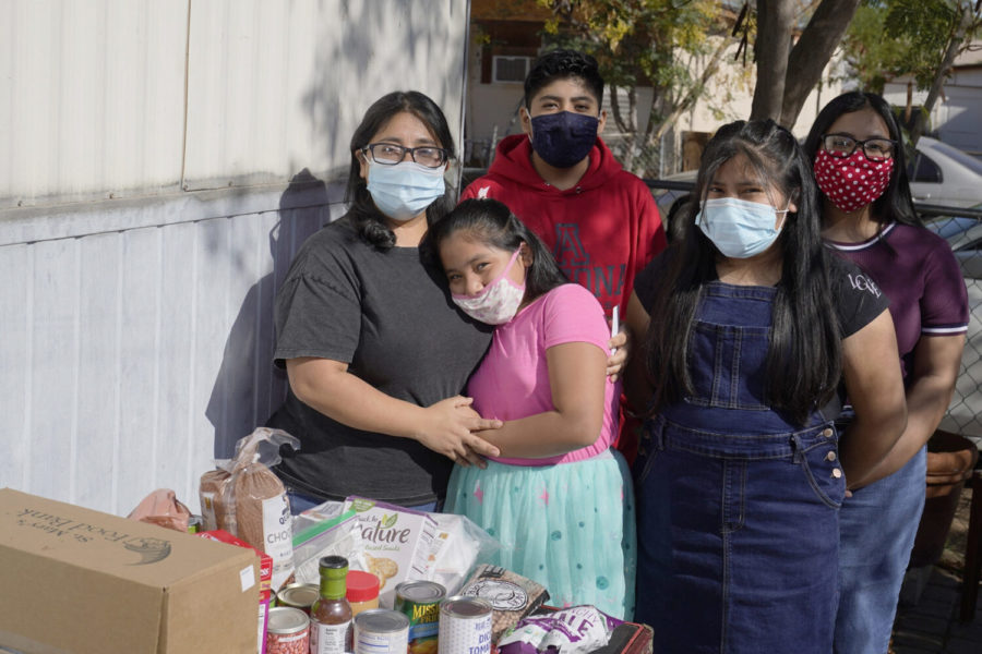 From left, Abigail Leocadio, stands with her children, Areli, 9, Eliel, 12, Zeret, 10, and Samai, 15, after a delivery from the Emmaus House food pantry Saturday, Nov. 14, 2020, in Phoenix. Leocadio says the food provides less than half of what her family eats in four weeks, but significantly reduces their monthly bill. Before the pandemic, the family was saving to buy a house, but that money has been wiped out. (AP Photo/Ross D. Franklin)