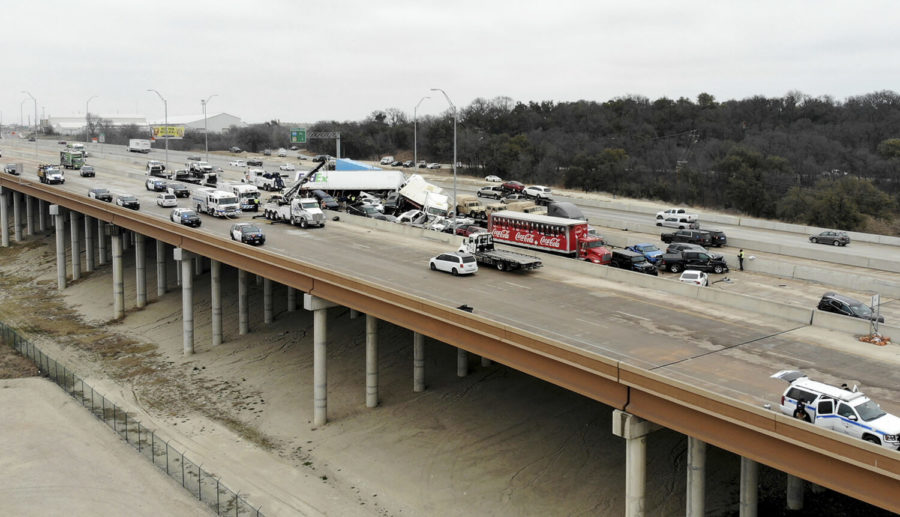 First responders work the scene of a fatal crash on I-35 near downtown Fort Worth on Thursday, Feb. 11, 2021.  Police say at some people were killed and dozens injured in a massive crash involving 75 to 100 vehicles on an icy Texas interstate.  (Amanda McCoy /Star-Telegram via AP)