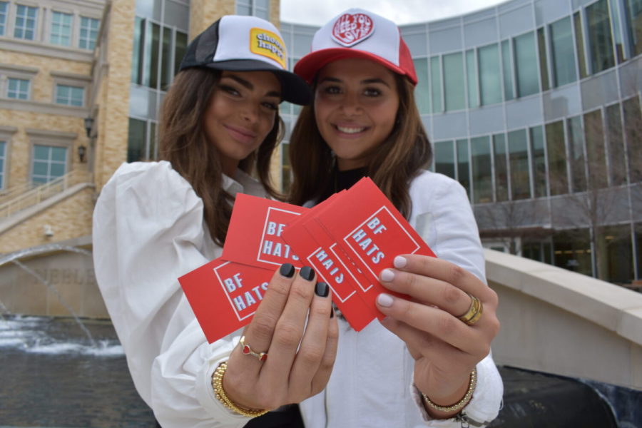 Bryn Carden (left) and Francesca Jabbour (right) pose in front of the Neeley School of Business at TCU with the products they launched. (Ryann Booth/TCU 360 Staff)