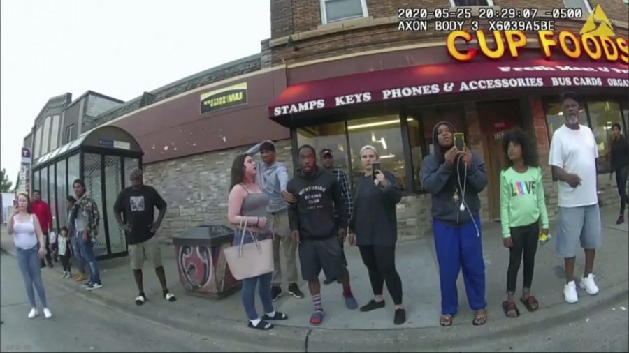 FILE - This May 25, 2020, file image from a police body camera shows bystanders including Alyssa Funari, left filming, Charles McMillan, center left in light colored shorts, Christopher Martin center in gray, Donald Williams, center in black, Genevieve Hansen, fourth from right filming, Darnella Frazier, third from right filming, as former Minneapolis police officer Derek Chauvin was recorded pressing his knee on George Floyds neck for several minutes in Minneapolis. To the prosecution, the witnesses who watched Floyds body go still were regular people -- a firefighter, a mixed martial arts fighter, a high school student and her 9-year-old cousin in a T-shirt emblazoned with the word Love. (Minneapolis Police Department via AP, File)