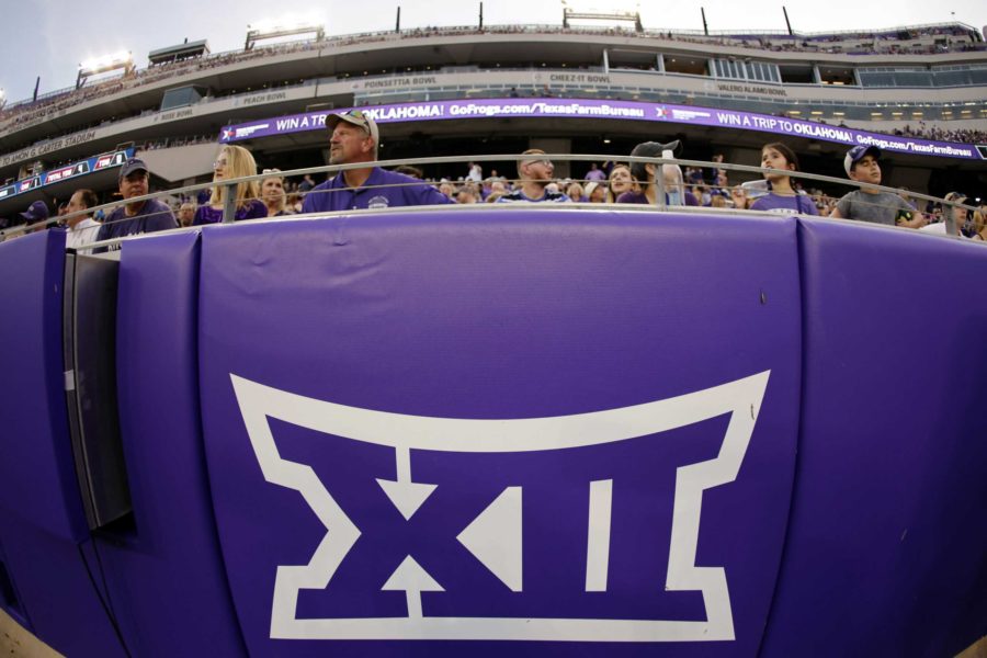 FILE - In this Saturday, Sept. 4, 2021, file photo, a Big 12 Conference logo is displayed on a barrier at Amon G. Carter Stadium before Duquesne played TCU in an NCAA college football game in Fort Worth, Texas. The Big 12 has extended membership invitations to BYU, UCF, Cincinnati and Houston to join the Power Five league. That comes in advance of the league losing Oklahoma and Texas to the Southeastern Conference.  (AP Photo/Ron Jenkins, File)