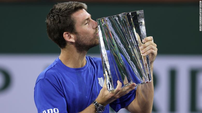 Cameron Norrie kisses his Indian Wells winner's trophy after a three set victory against Nikoloz Basilashvili.