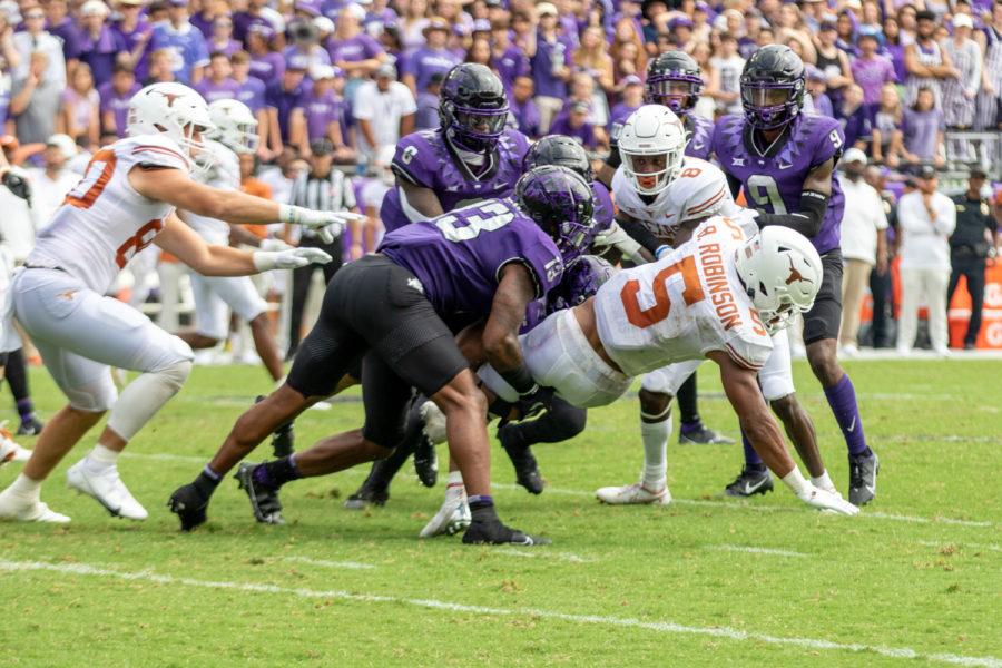 Texas running back Bijan Robinson (5) gets tackled by TCU linebacker Dee Winters (13) in the Frogs 32-27 loss to the Longhorns in Fort Worth on Oct. 2, 2021. (Esau Rodriguez/Staff Photographer)