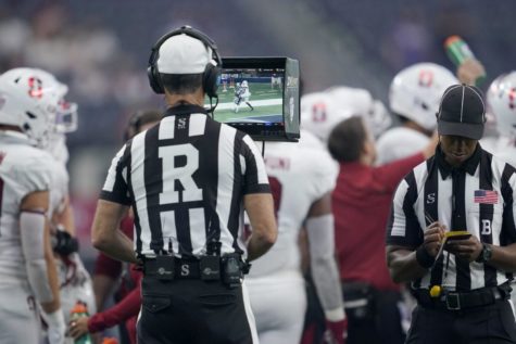 Referee Chris Coyte watches a replay during an NCAA college football game between Stanford and Kansas State in Arlington, Texas, Saturday, Sept. 4, 2021. (AP Photo/Tony Gutierrez)