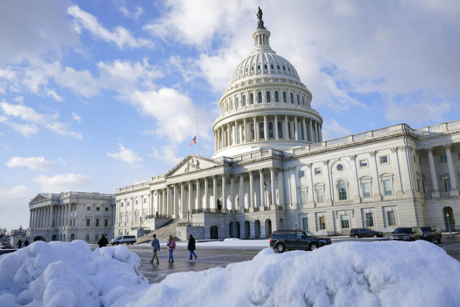 People walk outside the U.S. Capitol building in Washington, Friday, Jan. 7, 2022. (AP Photo/Patrick Semansky)