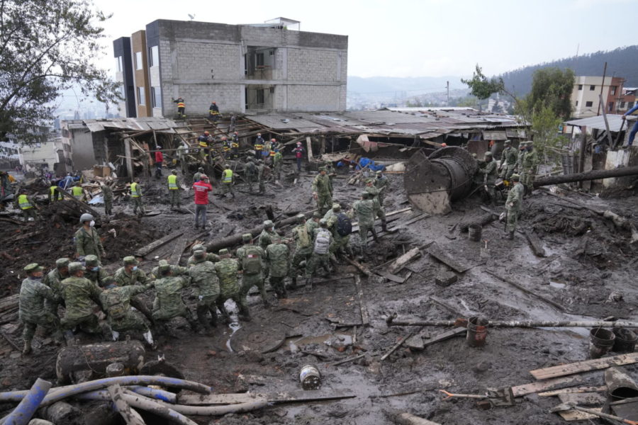 Soldiers work to remove large objects of debris from mud-filled streets after a rain-weakened hillside collapsed and brought waves of mud over La Gasca area of Quito, Ecuador, Wednesday, Feb. 2, 2022. (AP Photo/Dolores Ochoa)