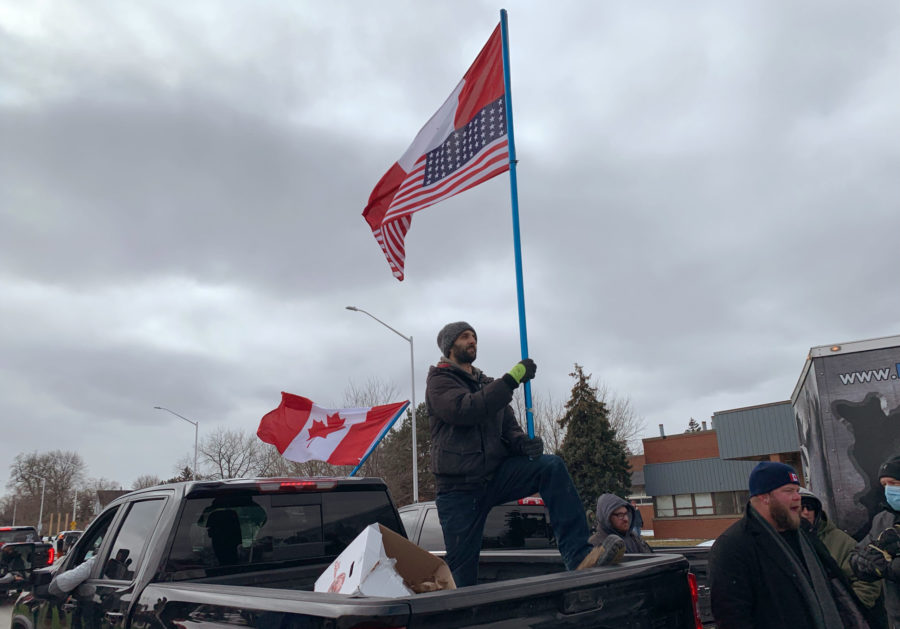 A protester waves Canada and U.S. flags in the backup of a pickup truck as police in Windsor, Ontario, moved protesters away from the entrance to the Ambassador Bridge, which has been blocked this week to Detroit, Saturday, Feb. 12, 2022. This weeks demonstrations at the Ambassador Bridge, downtown Ottawa and elsewhere have targeted vaccine mandates and other coronavirus restrictions. There is also an outpouring of fury toward Prime Minister Justin Trudeau who has called them a “fringe” of Canadian society.  (AP Photo/Mike Householder)