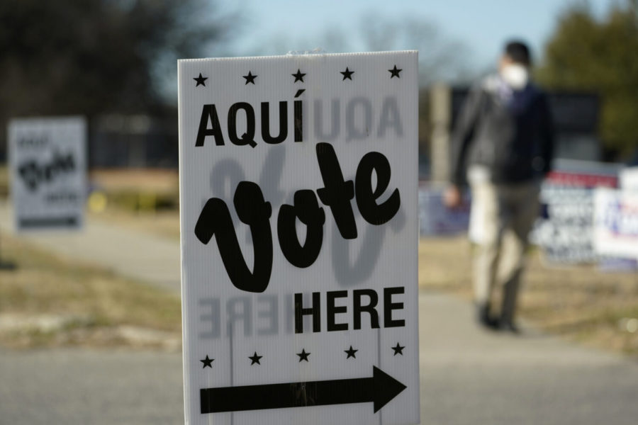 A man passes an early voting poll site, Monday, Feb. 14, 2022, in San Antonio. Early voting in Texas began Monday. (AP Photo/Eric Gay)