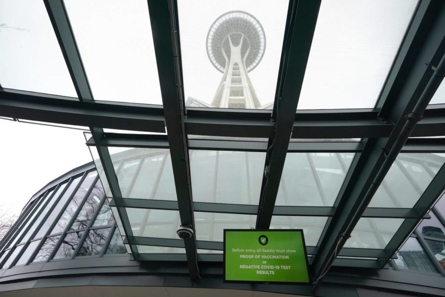 A video display that says guests at the Space Needle are required to show proof of vaccination or a negative COVID-19 test is shown, Thursday, Feb. 17, 2022, in Seattle. Gov. Jay Inslee said Thursday that the statewide indoor mask mandate in Washington state will lift on March 21, 2022, including at schools and child care facilities. (AP Photo/Ted S. Warren)
