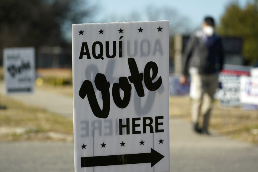 FILE - A man passes an early voting poll site, on Feb. 14, 2022, in San Antonio. Voters in Texas will usher in the midterm campaign season with primaries that will test just how far to the right the Republican Party will shift in a state where many in the GOP have already tightened their embrace of former President Donald Trump.(AP Photo/Eric Gay, File)