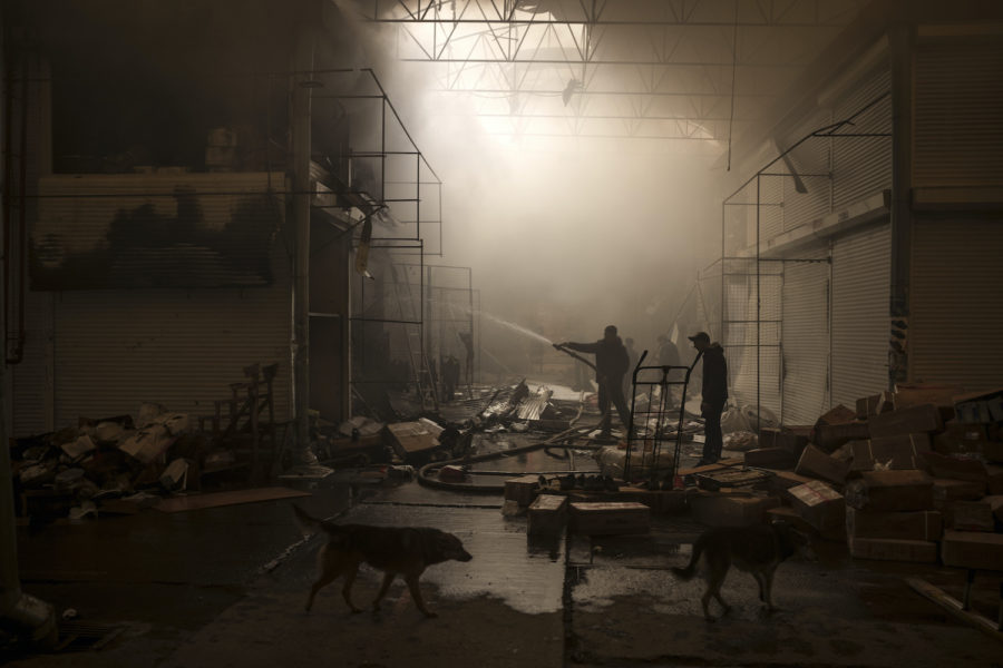 People try to extinguish a fire in a market after a Russian attack in Kharkiv, Ukraine, Friday, March 25, 2022. (AP Photo/Felipe Dana)