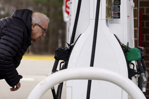A man checks gas prices at a gas station in Buffalo Grove, Ill. (AP Photo/Nam Y. Huh)