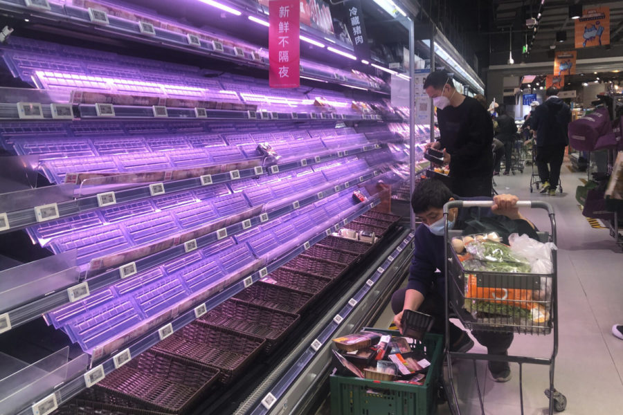 HOLD FOR STORY VIRUS OUTBREAK CHINA THAT IS FOCUED ON FOOD SHORTAGE FILE - Customers look through empty shelves at a supermarket in Shanghai, China, Wednesday, March 30, 2022. (AP Photo/Chen Si, File)
