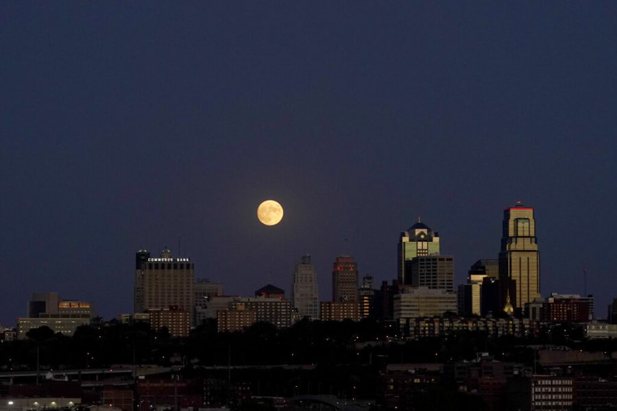 The downtown Kansas City skyline is outlined by the moon.  (AP Photo/Charlie Riedel)