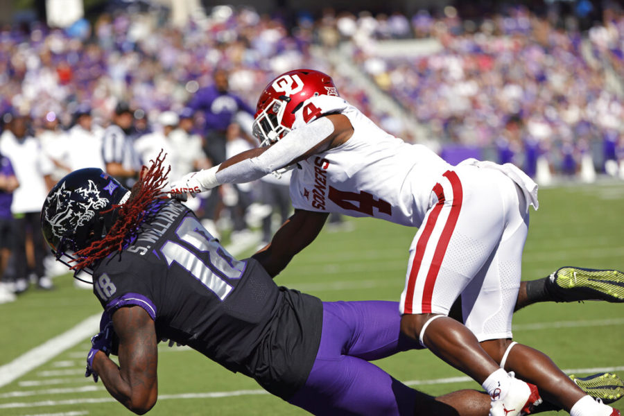 TCU wide receiver Savion Williams (18) catches a touchdown pass as Oklahoma defensive back Jaden Davis (4) defends during the first half of an NCAA college football game Saturday, Oct. 1, 2022, in Fort Worth, Texas. (AP Photo/Ron Jenkins)
