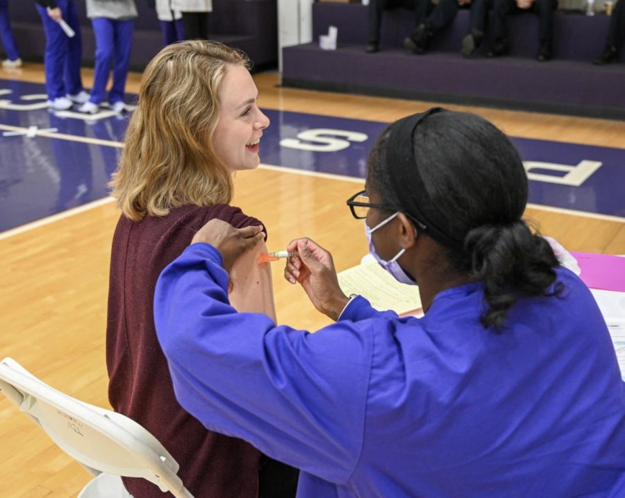 First-year MBA student Katie Matson receives a flu shot from senior nursing major Jernice Neal. (Sarah Walter/Staff Writer)
