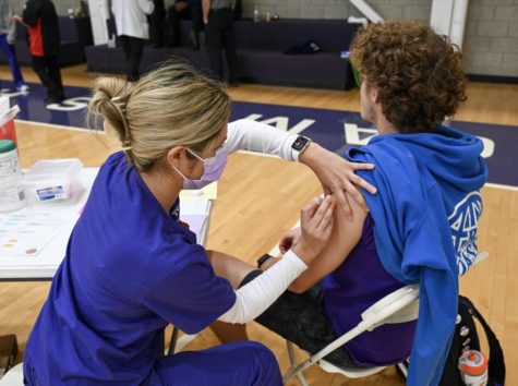 Jordan Meyer, a senior nursing major, prepares to administer a shot to junior English major Brendan Healy. (Sarah Walter/Staff Writer)