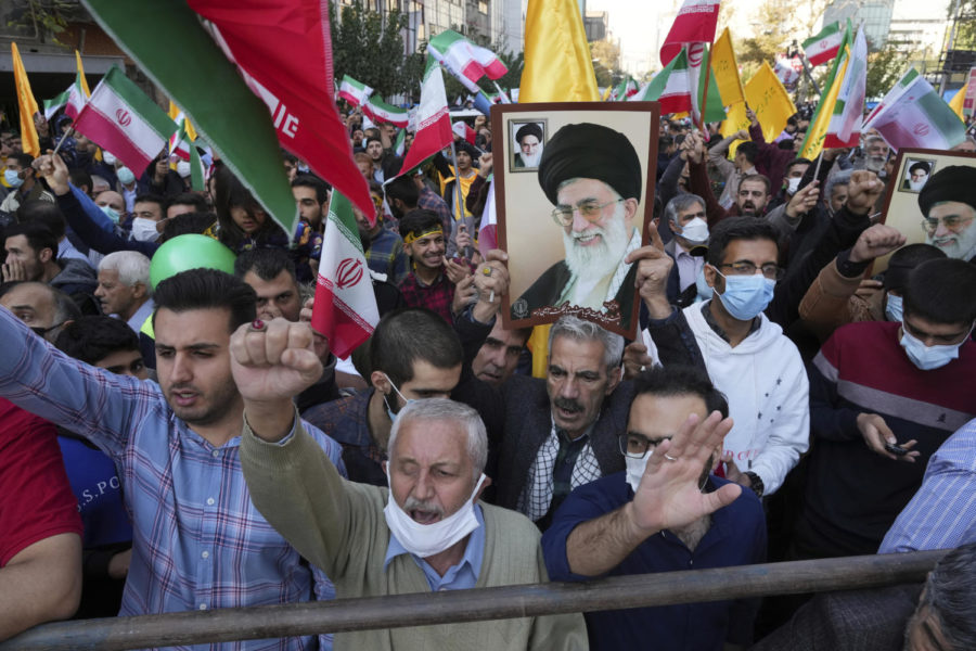 Demonstrators chant slogans as one of them holds up a poster of Iranian Supreme Leader Ayatollah Ali Khamenei during a demonstration in front of the former U.S. Embassy in Tehran, Iran, Friday, Nov. 4, 2022. Iran on Friday marked the 1979 takeover of the U.S. Embassy in Tehran as its theocracy faces nationwide protests after the death of a 22-year-old woman earlier arrested by the countrys morality police. (AP Photo/Vahid Salemi)