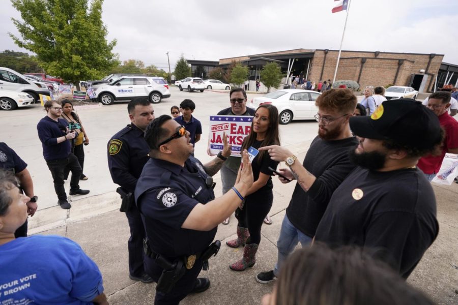 Dallas County Constables calm tensions down between persons with opposing views at a voting location in Dallas, Tuesday, Nov. 8, 2022. (AP Photo/Tony Gutierrez)