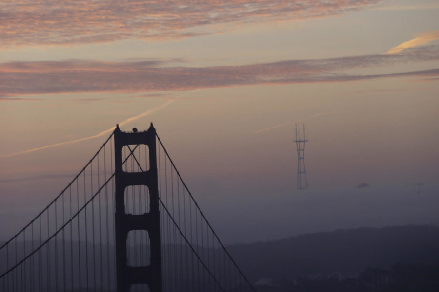 The Golden Gate Bridge towers over the fog-covered city at sunrise on Tuesday, Dec. 31, 2013, in San Francisco. (AP Photo/Marcio Jose Sanchez)