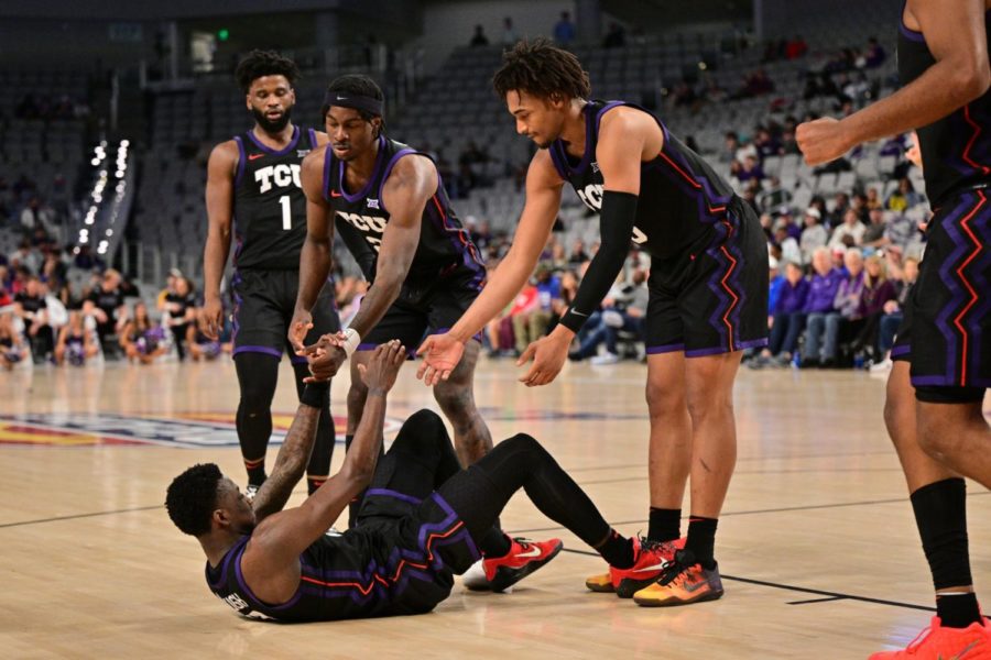 Guard Damion Baugh is helped up by teammates Emanuel Miller, Chuck OBannon Jr., and Mike Miles Jr. vs SMU on Dec. 10, 2022. (Photo courtesy of GoFrogs.com)