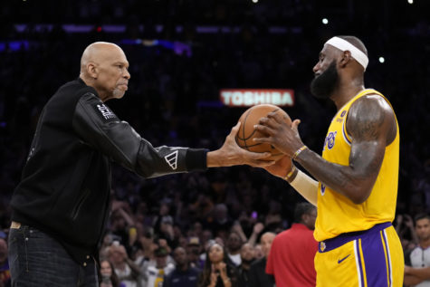 Kareem Abdul-Jabbar, left, hands the ball to Los Angeles Lakers forward LeBron James after passing Abdul-Jabbar to become the NBAs all-time leading scorer during the second half of an NBA basketball game against the Oklahoma City Thunder Tuesday, Feb. 7, 2023, in Los Angeles. (AP Photo/Ashley Landis)