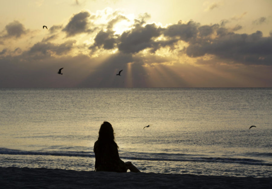 A woman meditates on the beach in Miami Beach, Fla., on Wednesday, April 28, 2010. Meditation is one way to practice mindfulness in everyday life. (AP Photo/Lynne Sladky, File)