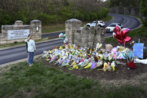 People pay their respects at an entry to The Covenant School that has become a memorial for victims, Tuesday, March 28, 2023, in Nashville, Tenn. Six people were fatally shot at the school the day before. (AP Photo/John Amis)