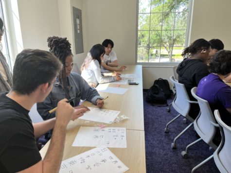 Drake Williams teaches a student how to write a Kanji character at the Japanese language and culture association’s AAPINH week event on April 12, 2023. (Walter Flanagin/TCU360)
