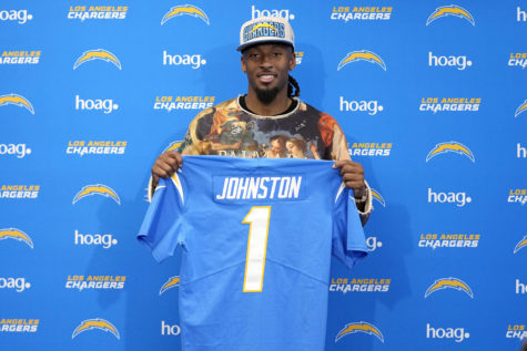 Quentin Johnston poses with his jersey after speaking at a news conference Friday, April 28, 2023, in Costa Mesa, Calif. to introduce him after he was drafted Thursday by the Los Angeles Chargers. The TCU wide receiver was the 21st pick in the NFL draft. (AP Photo/Mark J. Terrill)