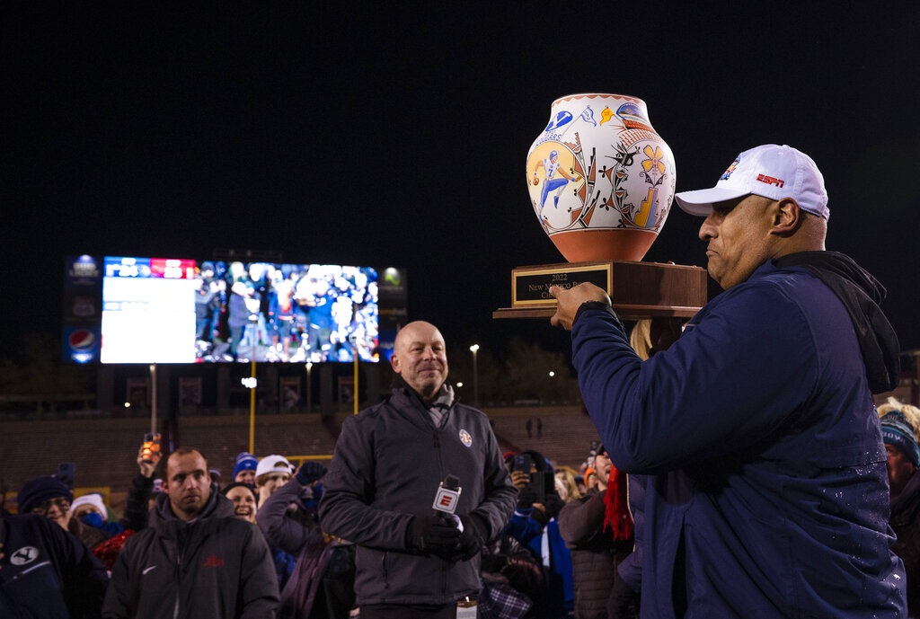 BYU head coach Kalani Sitake, right, holds the trophy during celebrations the teams victory in the New Mexico Bowl NCAA college football game against SMU in Albuquerque, N.M., Saturday, Dec. 17, 2022. (Chancey Bush/The Albuquerque Journal via AP)