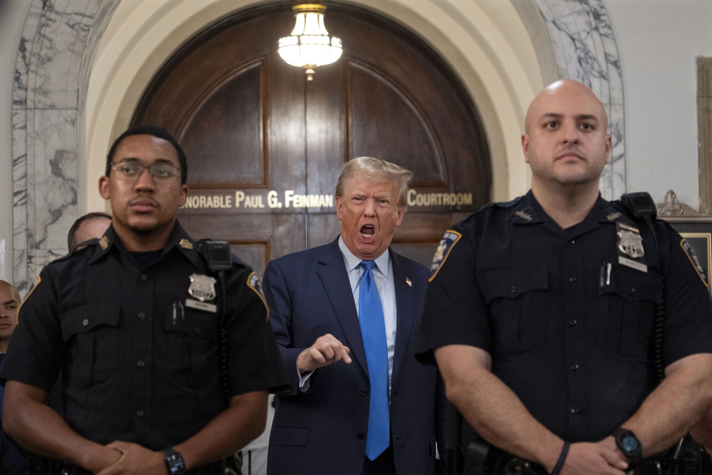 Former President Donald Trump speaks with journalists during a midday break from court proceedings in New York, Monday, Oct. 2, 2023.