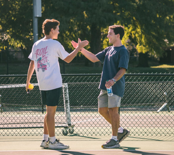 Two TCU students high-fiving while playing pickleball during club hours at the TCU Tennis Courts. (Photo courtesy of: Kate Woolsen)
