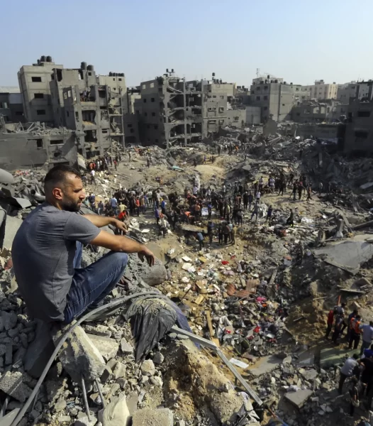 A man sits on the rubble overlooking the debris of buildings destroyed by Israeli airstrikes in Jabaliya refugee camp, northern Gaza Strip, Wednesday, Nov. 1, 2023. 