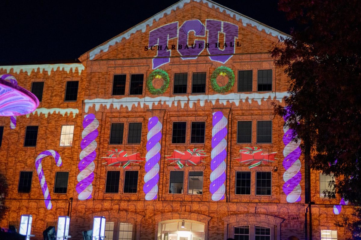 A TCU light display reflects off of Scharbauer Hall during the annual TCU Christmas tree lighting event. (Lance Sanders / TCU 360)
