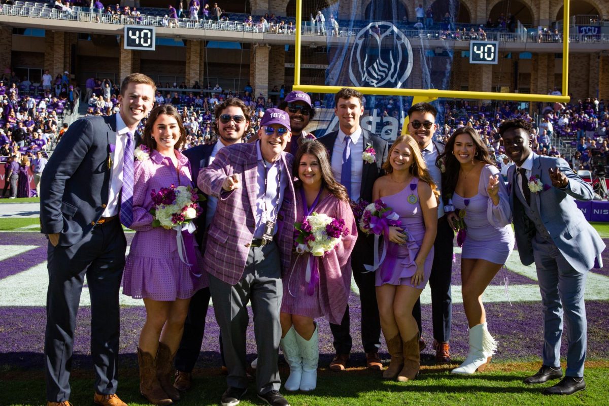 Marina Magnant poses with the nine other outstanding senior nominees and Chancellor Boschini on TCU’s football field at halftime of the homecoming football game. 
