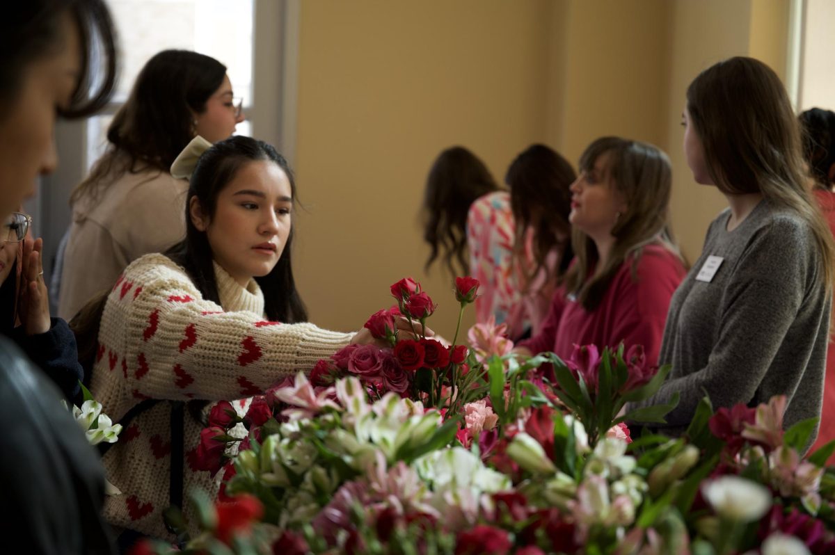 A student selects roses for a bouquet during a Valentine’s Day event sponsored by TCU CARE and SURS. (Paxton Crews/Staff Photographer)
