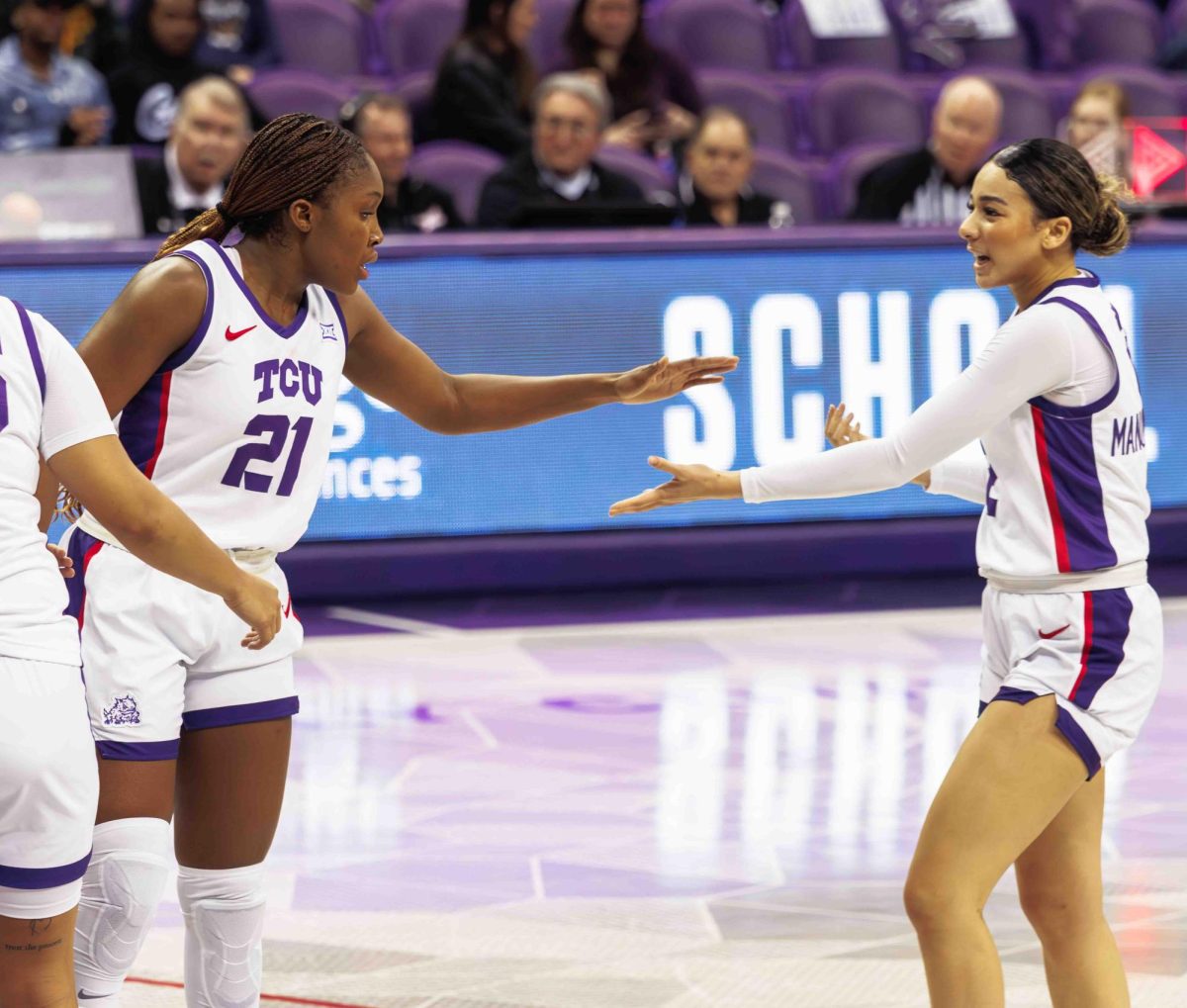 TCU players Agnes Emma-Nnopu and Tara Manumaleuga slap hands at Ed and Rae Schollmaier Arena in Fort Worth, Texas on February 3, 2024. The TCU Horned Frogs fell to the Kansas Jayhawks 74-81. (TCU360/ Tyler Chan)