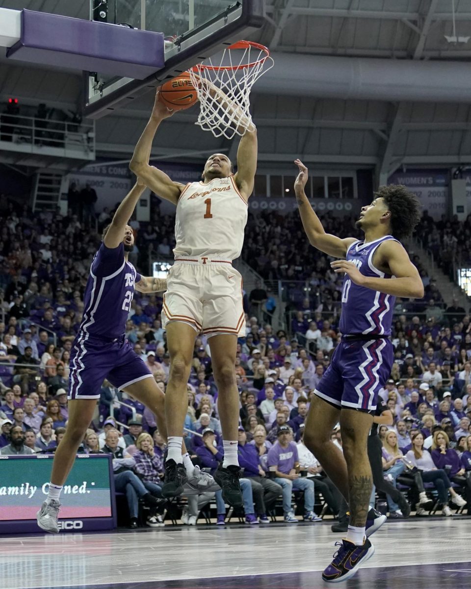Texas forward Dylan Disu (1) takes a shot between TCUs JaKobe Coles, left, and Micah Peavy (0) in the first half of an NCAA college basketball game, Wednesday, March 1, 2023, in Fort Worth Texas. (AP Photo)