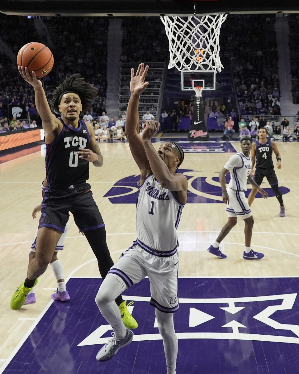 TCU guard Micah Peavy (0) gets past Kansas State forward David NGuessan (1) to put up a shot during the first half of an NCAA college basketball game Saturday, Feb. 17, 2024, in Manhattan, Kan.