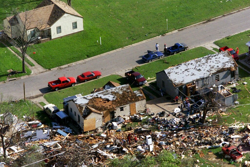 FILE - In this March 29, 2000 file photo, a house on the west side of Fort Worth, Texas, sits undamaged while homes across the street were severely damaged by a tornado that hit the area.  Its been nearly 20 years since the tornado lumbered through downtown Fort Worth and experts say the deadly storm left behind more than just destruction. The Fort Worth Star-Telegram reports that experts say the twister in 2000, which caused an estimated $400 million in damage, triggered a valuable opportunity for business redevelopment and more housing. Insurance Council of Texas records show the tornado that killed two people in Fort Worth was the 21st costliest storm in state history.  (AP Photo/Donna McWilliam, File)