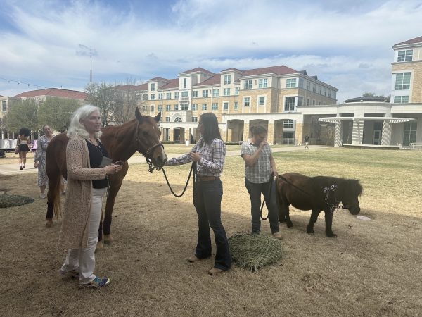 Lesli Figueredo explains the benefits on equine therapy in the TCU commons. (Shalyn Minshew/Staff Photographer)