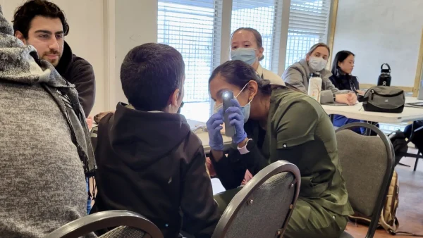 Texas College of Osteopathic Medicine student Fatema Jafferji assesses a boy’s throat at a Refugee Health Initiative clinic in November 2022. The boy and his family are refugees from Syria. (Photo courtesy of Stephanie Elbanna) 