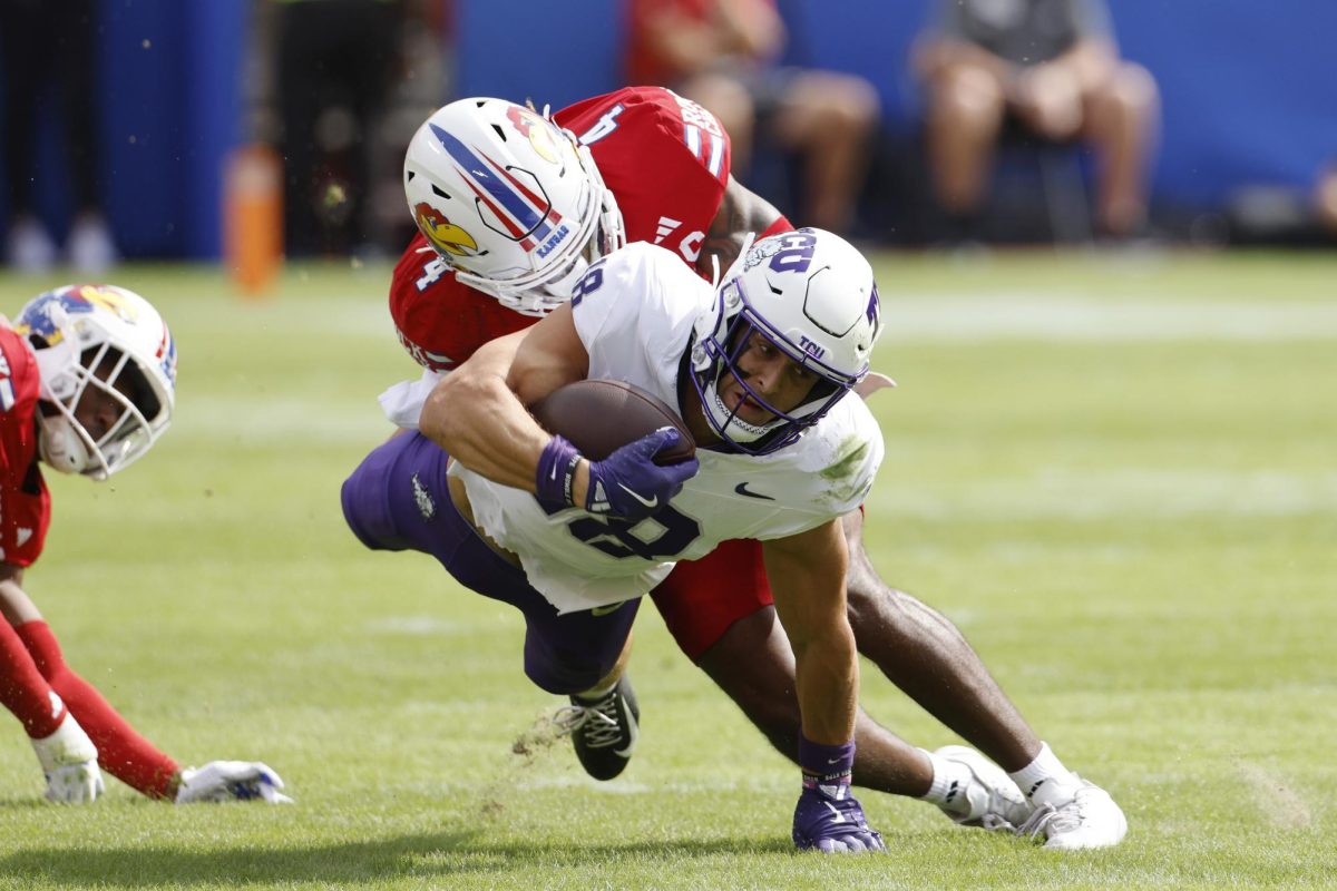 TCU wide receiver Jack Bech (18) is tackled by Kansas safety Marvin Grant (4) after catching a pass for a first down during the first half of an NCAA football game on Saturday, Sept. 28, 2024, in Kansas City, Mo. (AP Photo/Colin E. Braley)